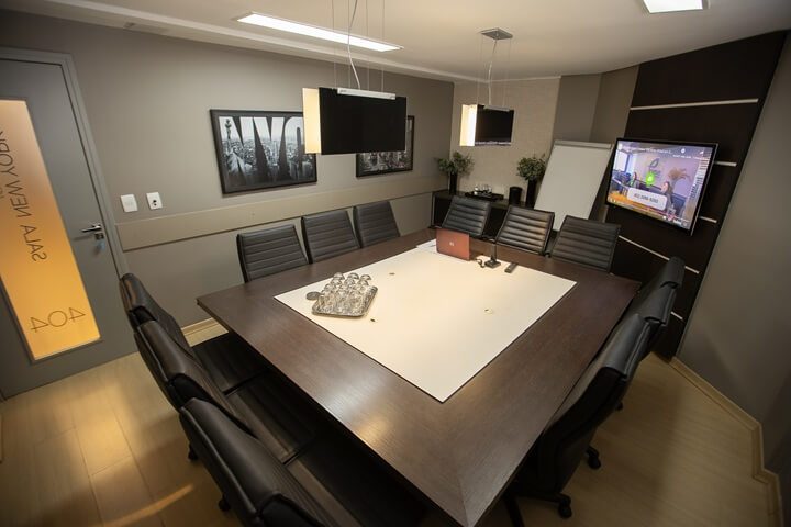 Sala de reunião em Goiânia — Sala New York vazia com 12 lugares, mesa executiva e TV para apresentação no Setor Marista