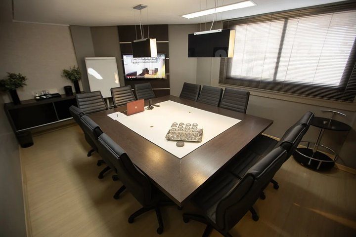 Sala de reunião em Goiânia — Sala New York vista panorâmica, mesa executiva ampla com 12 lugares e duas TVs no Setor Marista